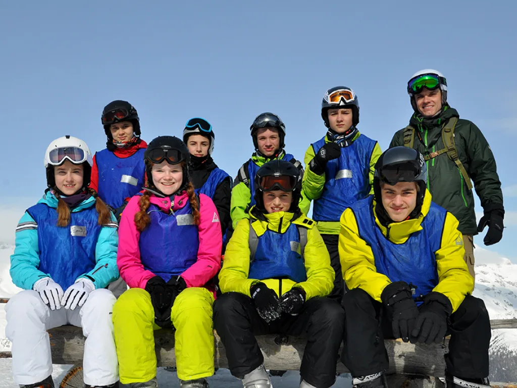 Kleinere Gruppe posiert im Schnee für ein Foto.